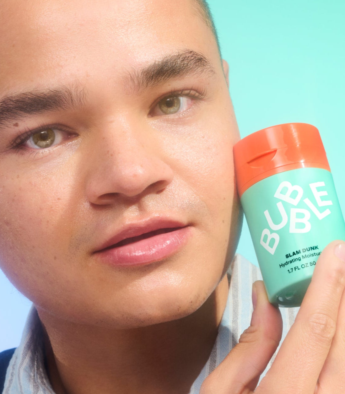 Person holding a 'BUBBLE' product against a light blue background